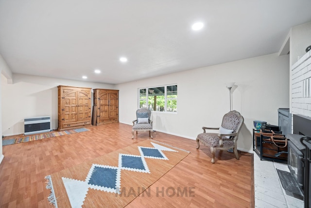 sitting room with hardwood / wood-style floors and heating unit