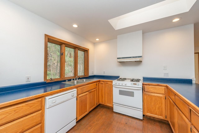 kitchen featuring a skylight, dark wood-type flooring, sink, and white appliances