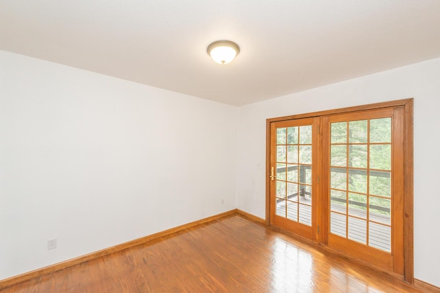 unfurnished room featuring wood-type flooring and a healthy amount of sunlight