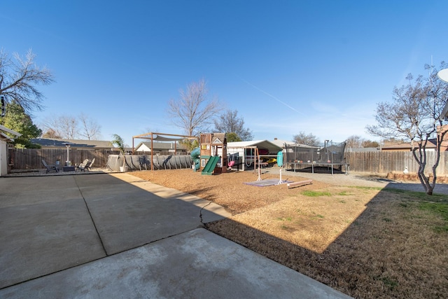 view of yard with a trampoline, a patio area, and a playground