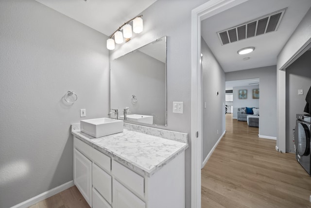 bathroom featuring wood-type flooring, washer / dryer, and vanity