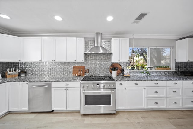 kitchen with white cabinets, stainless steel appliances, and wall chimney exhaust hood