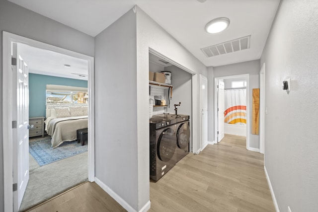 hallway featuring separate washer and dryer and light hardwood / wood-style floors