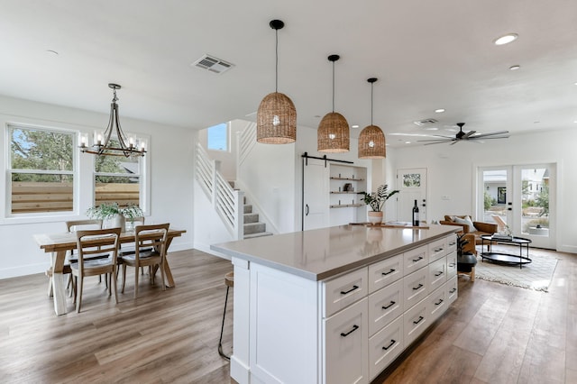 kitchen featuring white cabinetry, hardwood / wood-style floors, pendant lighting, and a center island