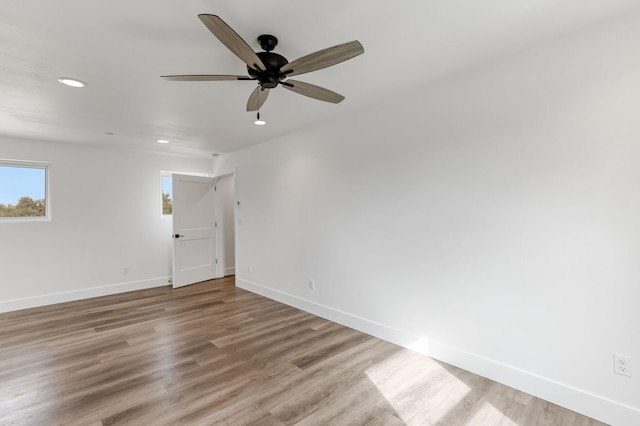 empty room with ceiling fan and light hardwood / wood-style floors