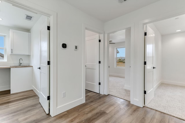 hall with sink and light hardwood / wood-style flooring