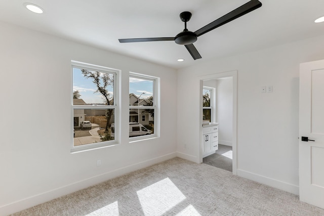 unfurnished bedroom with ceiling fan, connected bathroom, and light colored carpet