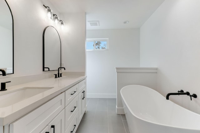 bathroom with vanity, tile patterned floors, and a bathtub