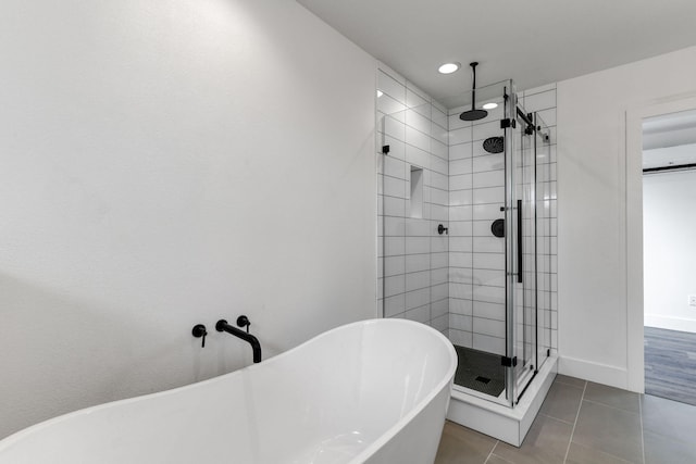 bathroom with independent shower and bath and tile patterned floors