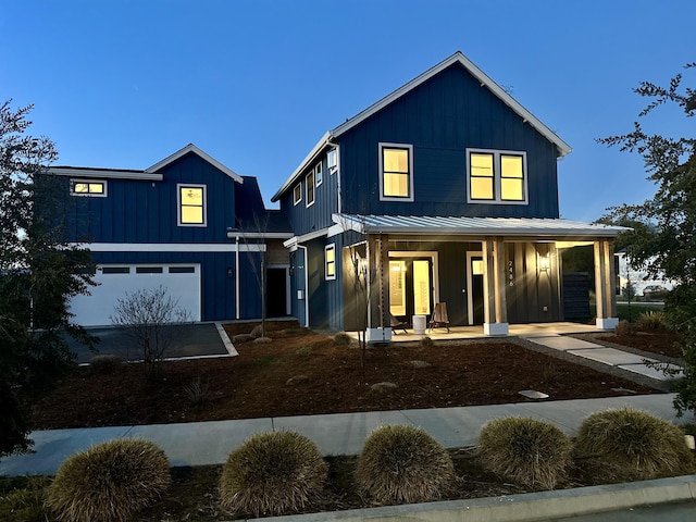 modern farmhouse featuring a garage and a porch