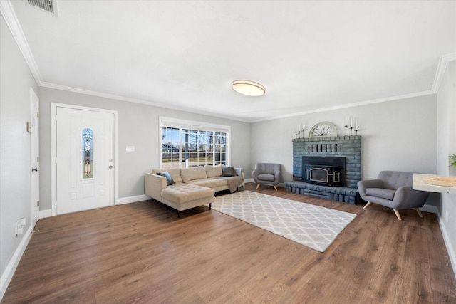 living room featuring a brick fireplace, crown molding, and wood-type flooring