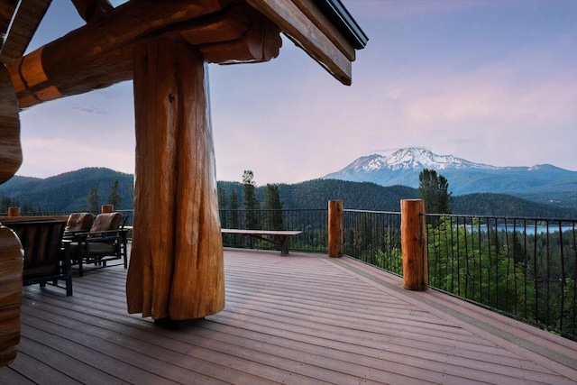 deck at dusk featuring a mountain view