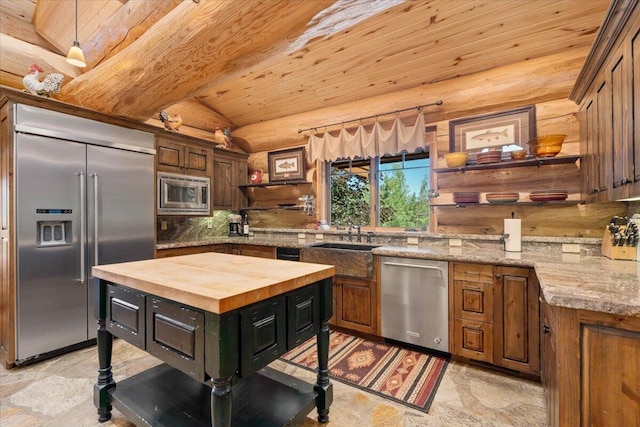 kitchen featuring butcher block counters, built in appliances, vaulted ceiling with beams, sink, and wooden ceiling