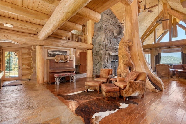 living area featuring log walls, wood ceiling, beamed ceiling, high vaulted ceiling, and ceiling fan