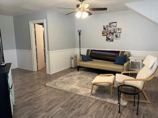 living area featuring ceiling fan and dark hardwood / wood-style flooring