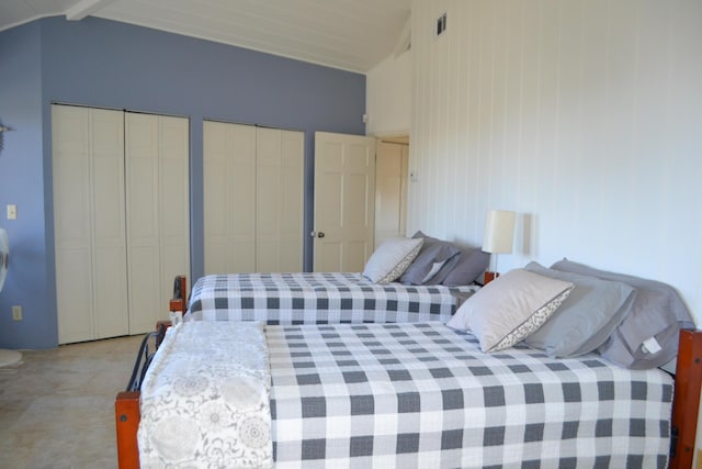 bedroom with lofted ceiling and two closets