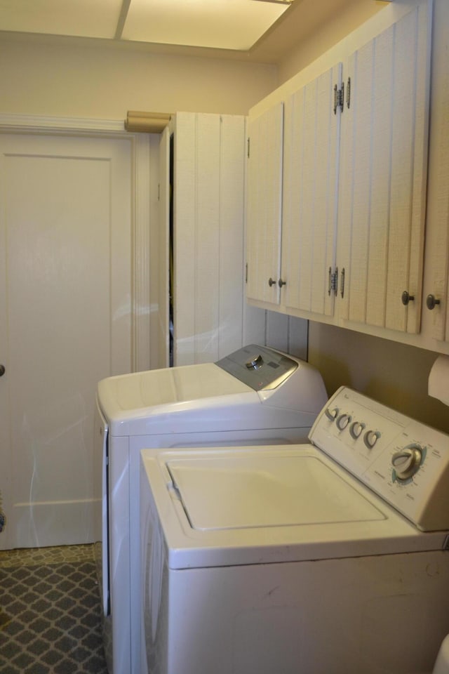 washroom with washing machine and clothes dryer and cabinets