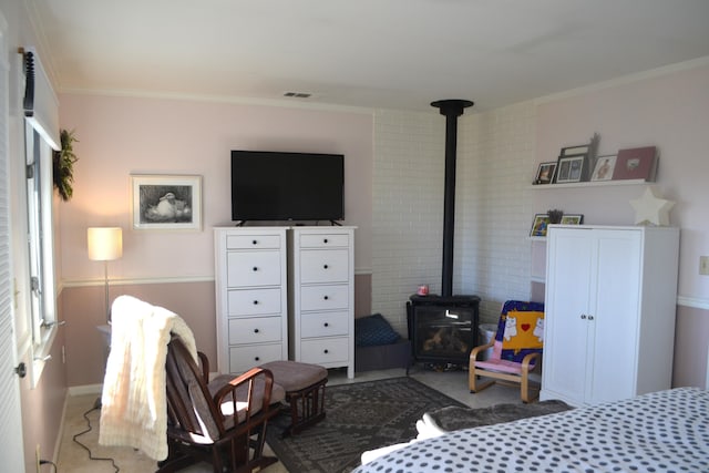 bedroom with a wood stove and crown molding