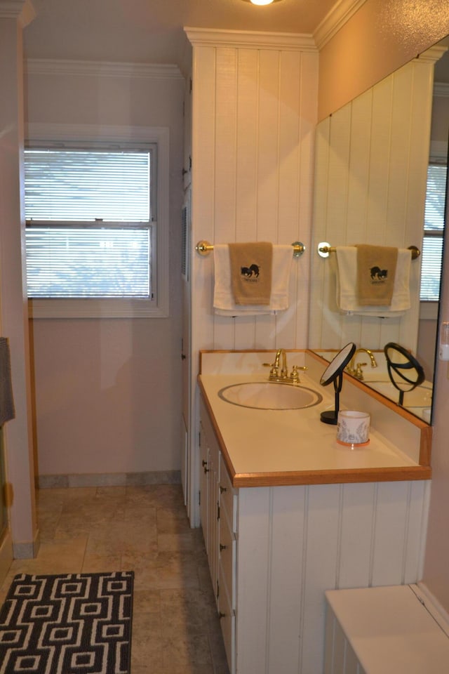 bathroom with a wealth of natural light, tile patterned floors, vanity, and ornamental molding