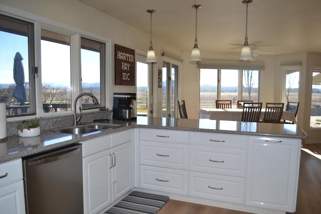 kitchen with sink, white cabinetry, stainless steel dishwasher, and kitchen peninsula