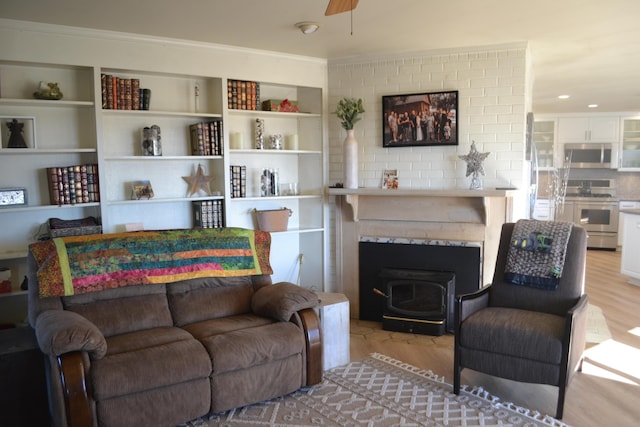 living room with ceiling fan, light hardwood / wood-style flooring, and ornamental molding