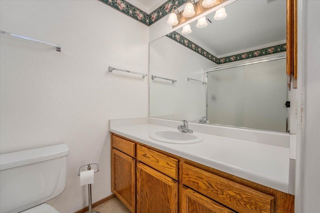 bathroom with vanity, a shower with shower door, and toilet