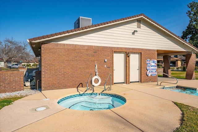 view of swimming pool with cooling unit, a community hot tub, and a patio