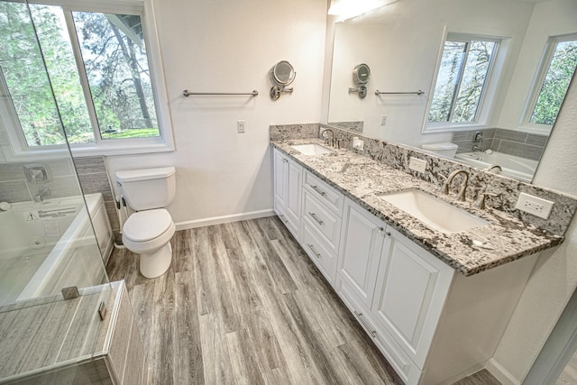 bathroom with toilet, vanity, wood-type flooring, and a washtub