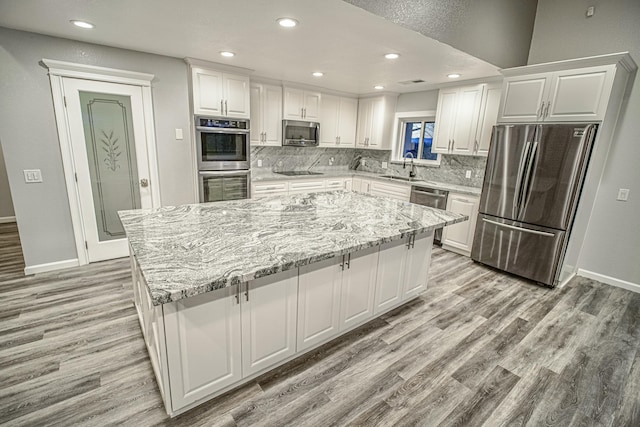 kitchen with white cabinets, stainless steel appliances, and a large island