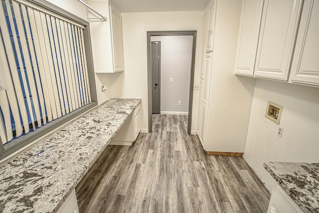 laundry room featuring hardwood / wood-style floors, washer hookup, and cabinets