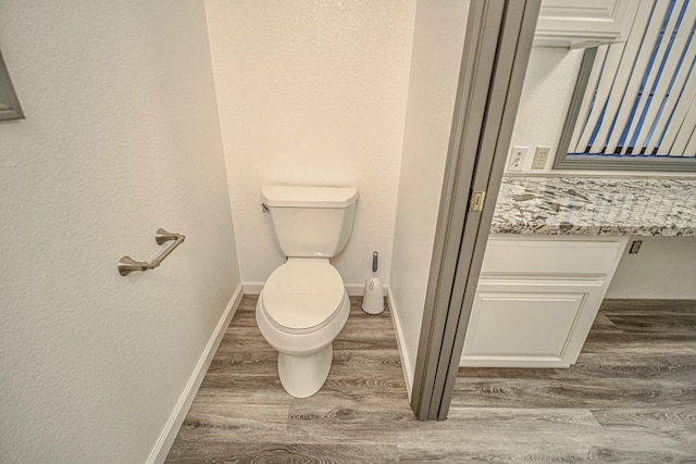 bathroom with toilet and hardwood / wood-style flooring