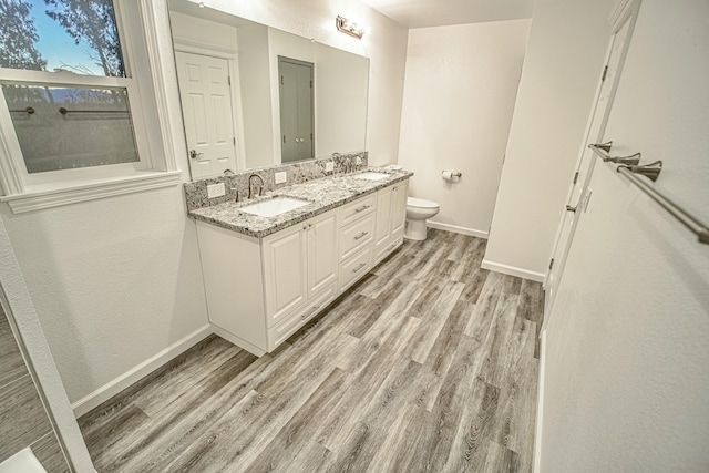 bathroom featuring toilet, hardwood / wood-style flooring, and vanity