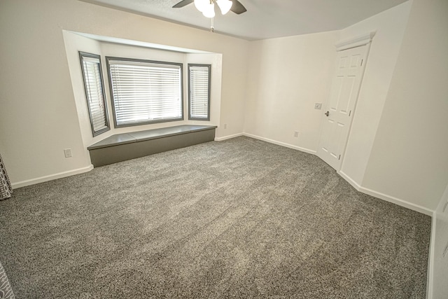 empty room with ceiling fan and dark carpet