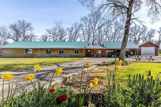 view of front of home with a garage, a front yard, and an outbuilding