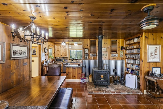 dining area with built in features, wood walls, wood ceiling, and dark tile patterned flooring