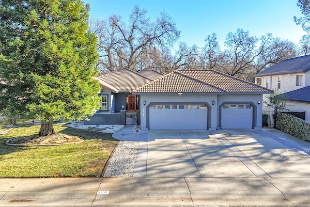 mediterranean / spanish home featuring a garage and a front lawn