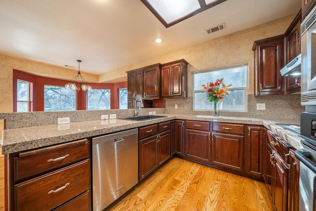 kitchen featuring sink, light hardwood / wood-style flooring, stainless steel dishwasher, pendant lighting, and backsplash