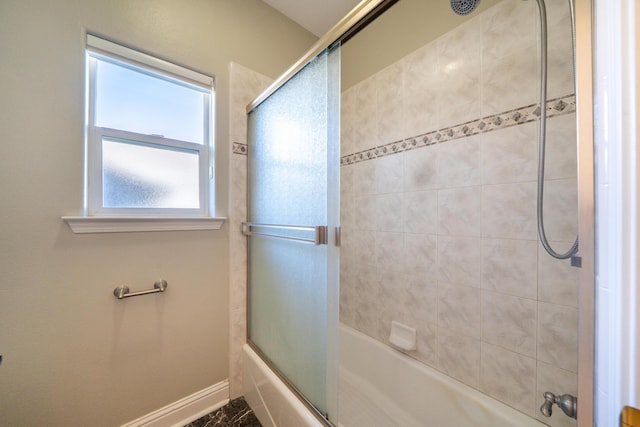 bathroom with bath / shower combo with glass door