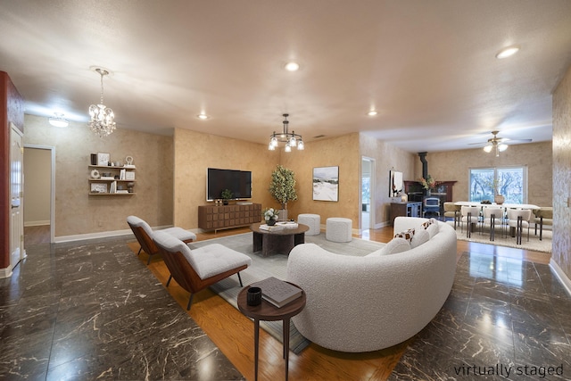 living room with ceiling fan with notable chandelier