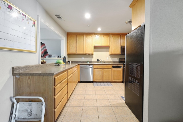 kitchen featuring light tile patterned flooring, appliances with stainless steel finishes, light brown cabinetry, and sink