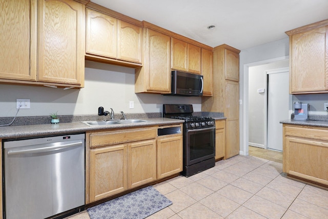 kitchen with stainless steel appliances, light brown cabinetry, sink, and light tile patterned floors
