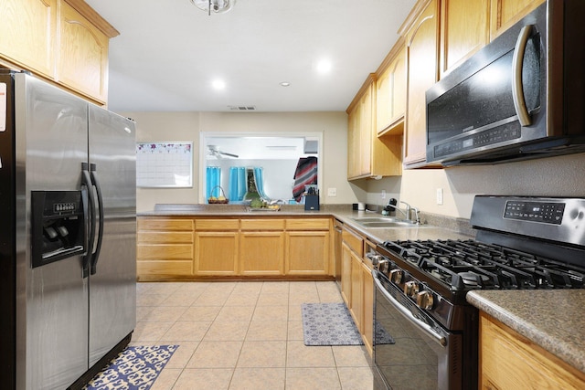 kitchen featuring stainless steel appliances, light brown cabinetry, sink, and light tile patterned floors