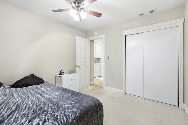 carpeted bedroom featuring ceiling fan, washer / dryer, and a closet
