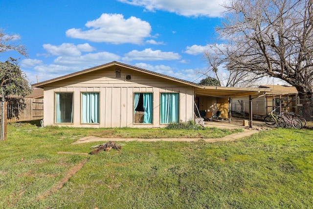rear view of house featuring a lawn