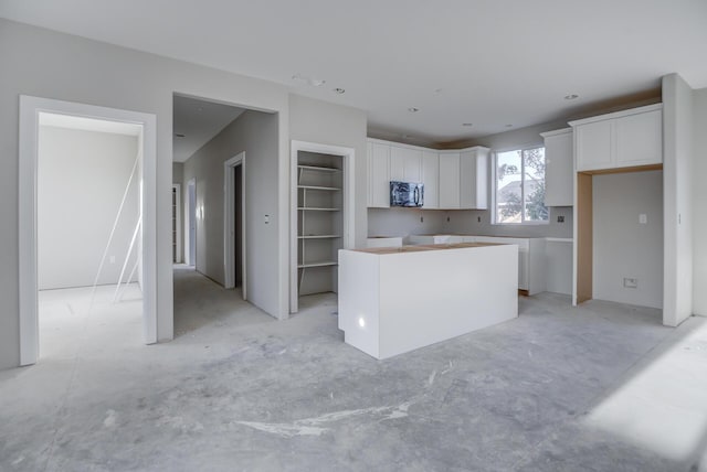 kitchen with white cabinetry, built in features, and a kitchen island