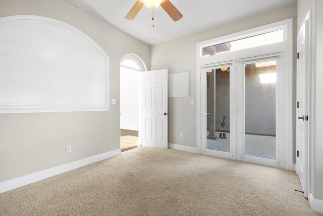 empty room featuring ceiling fan, a healthy amount of sunlight, and light carpet