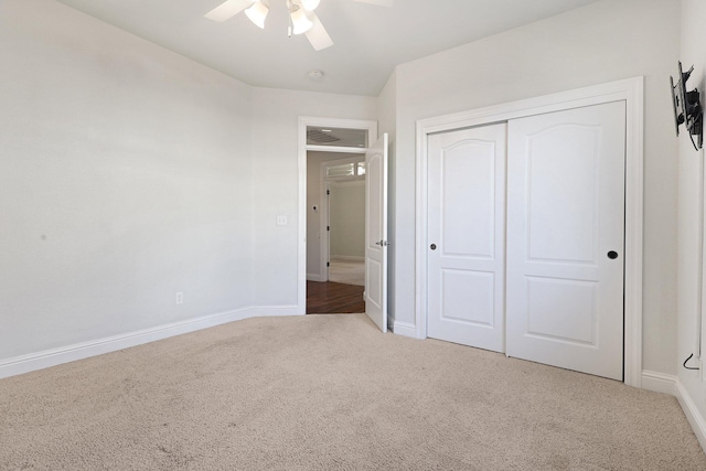 unfurnished bedroom featuring carpet, ceiling fan, and a closet