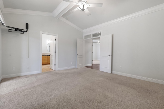 unfurnished bedroom with ceiling fan, ensuite bathroom, lofted ceiling with beams, ornamental molding, and light colored carpet