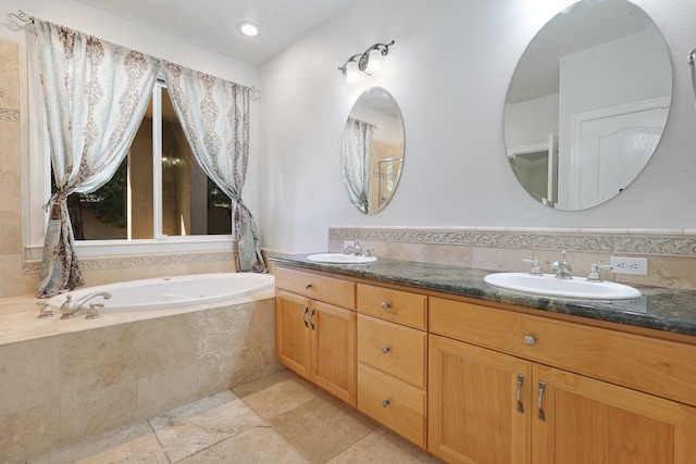 bathroom with vanity and a relaxing tiled tub