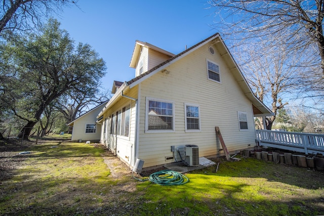 back of property with a deck, a lawn, and central air condition unit